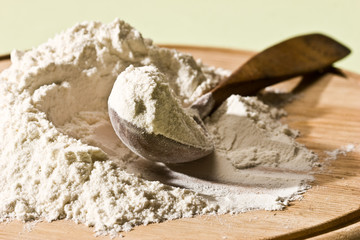 wheat flour on the wooden board with spoon