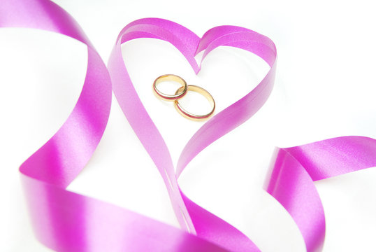 Wedding rings in the purple ribbon in the shape of heart