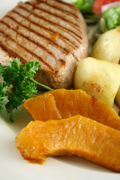 Hearty dinner of steak, vegetables and a side salad.