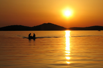 Naklejka na ściany i meble Boating in sunset