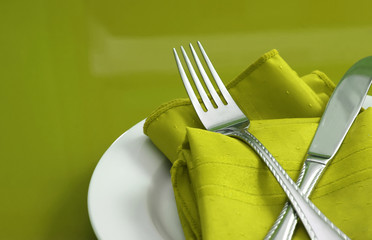 An elegant holiday table setting with fork, knife and napkin