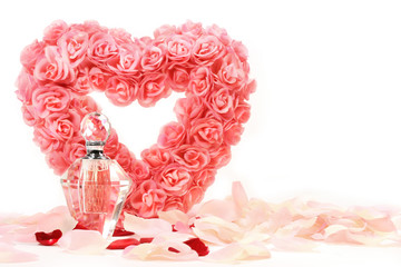 Heart of roses with perfume bottle on white background