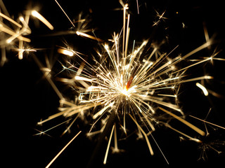 A lit sparkler showing bright sparks
