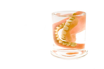 artificial teeth in a glass of water - obrazy, fototapety, plakaty