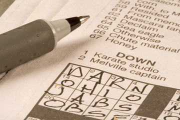 Newspaper crossword puzzle being solved by exercising the brain