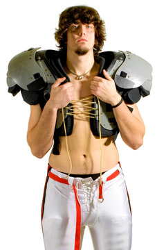 American football player. Shirtless holding shoulder pads.