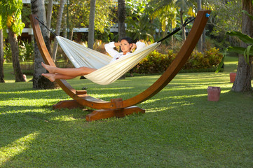 woman portrait ralaxing on hammock at exotic surrounding