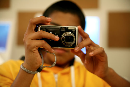 Young man taking pictures with a digital camera
