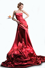 beautiful girl in a long red dress holds an flower in a hand