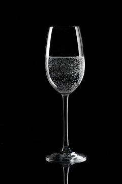Soda on champagne glass, black background