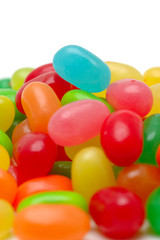 Close up of colorful jelly beans over white background