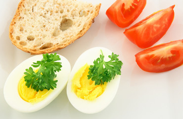 Simple meal. Cooked eggs, whole-grain bread and tomatos.