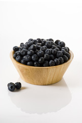 blueberries on a wooden bowl , isolated over white background