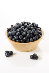 blueberries on a wooden bowl , isolated over white background