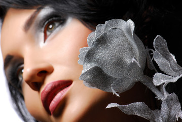 Attractive young girl with silver rose looking away... 
