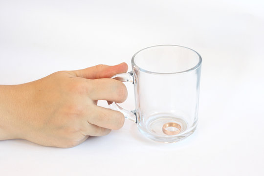 glass mug with gold(en) ring in hand