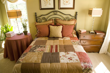 Country style bedroom with quilted bed cover.
