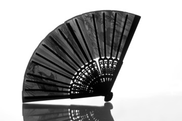 Silhouette of open black fan with reflection