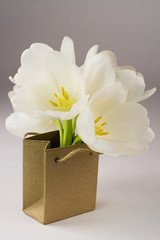 Brown paper bag  with white tulips