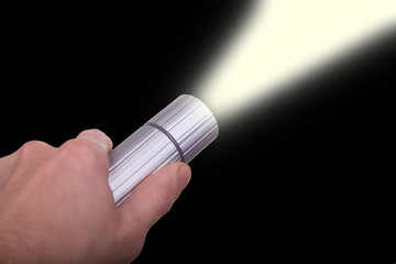 male hand holding lit flashlight in the night
