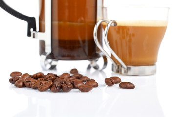 A cup and coffee pot, reflected on white background. Shallow DOF