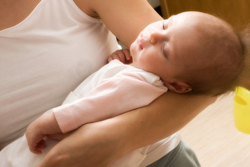 Cute sleeping baby 1,5 month in the hands of mother