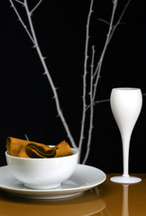A table set for dinner with plate and wine glass in orange