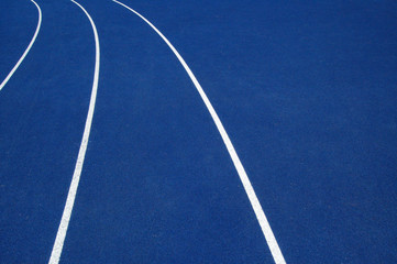 Arching white lines on blue running track