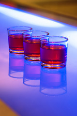 3 shot glasses on a bar
