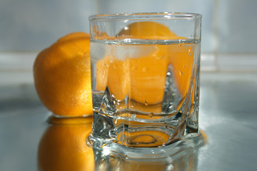 Glass of clear water and oranges