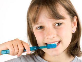 Girl brushing her teeth against a white background