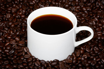 Cup of coffee on the coffee beans.