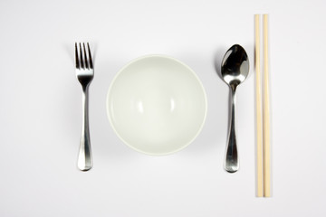 A place setting for an asian dish against white background