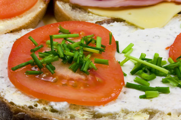 Tomato and chive on sandwich on plate
