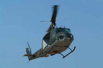 Military helicopter with camouflage paint hovering