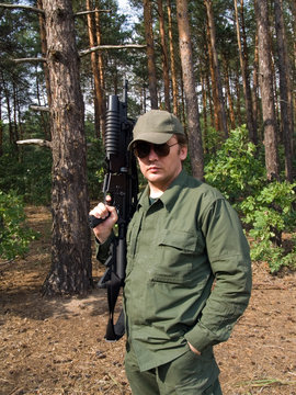 Soldier in olive uniform holding his gun (no clip attached)