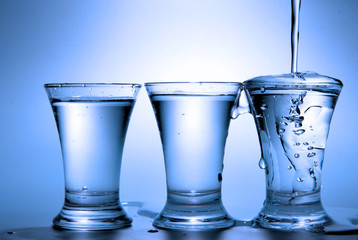 Vodka pour into glass toned in blue color