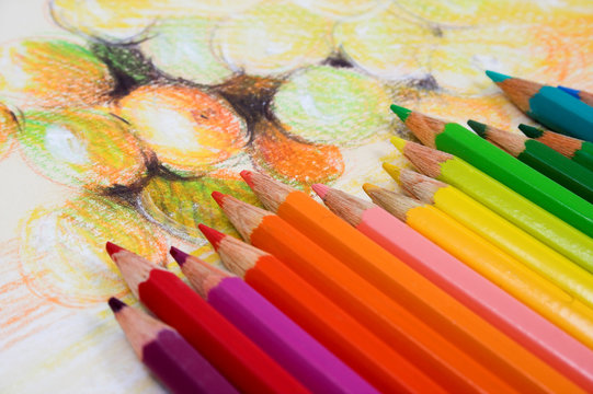Assortment of coloured pencils on draw background