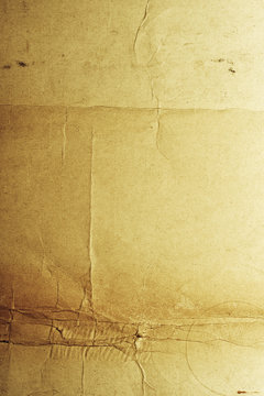 Yellow-brown messy rough old paper with cracs and folds