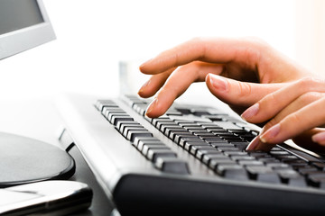 A business lady’s hands on the keys typing documents