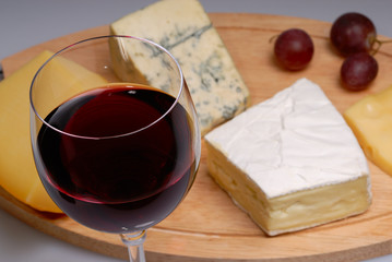 Glass of red wine and cheese plate