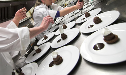 chefs preparing chocolate pastries in kitchen