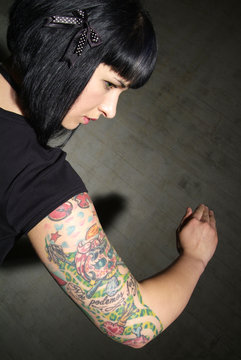 a woman with black hair and tattooed upper arm