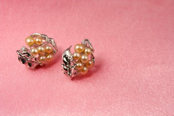 Jewelry pearl presents on pink silk background