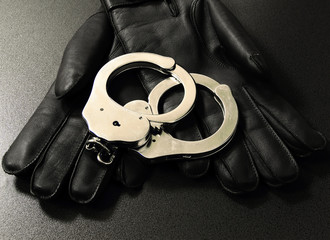 Handschellen liegen auf Handschuhen