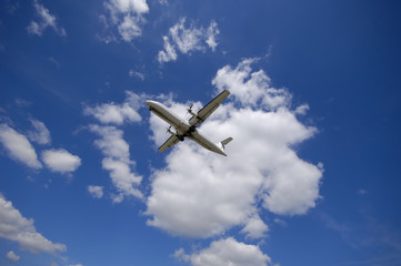 Fototapeta na wymiar Plane on a blue and cloudy sky