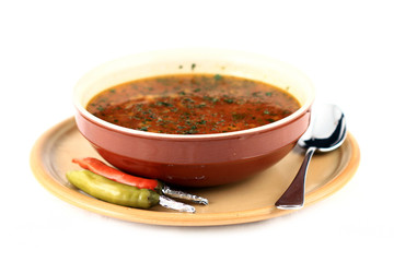 close up of a beef soup plate and two peppers