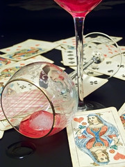 plaing cards and two red wine wineglasses with ice
