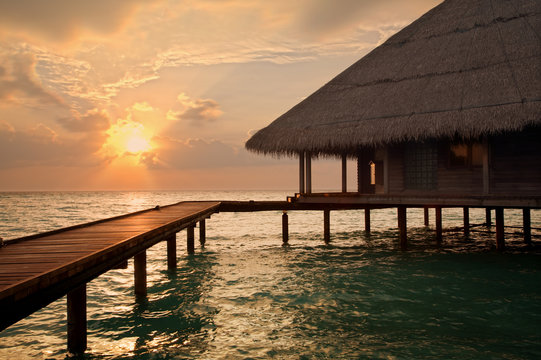 tropical beach: sunset over water. Copy space and sun beams