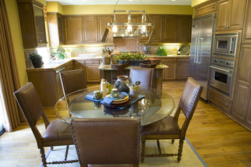 Spacious kitchen with a table and hardwood floor.
